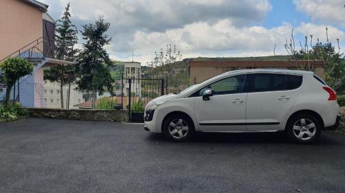une petite voiture blanche garée sur un parking dans l'établissement Studio le Puy-en-Velay, au Puy-en-Velay