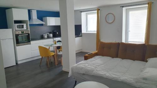 a bedroom with a bed and a kitchen with a table at Studio le Puy-en-Velay in Le Puy en Velay