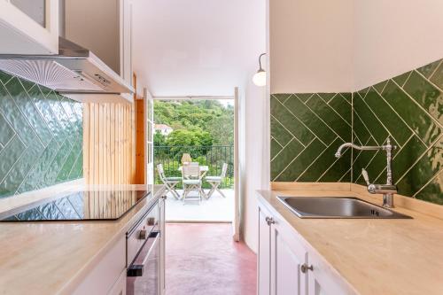 a kitchen with a sink and a view of a patio at Casa da Paderna in Sintra