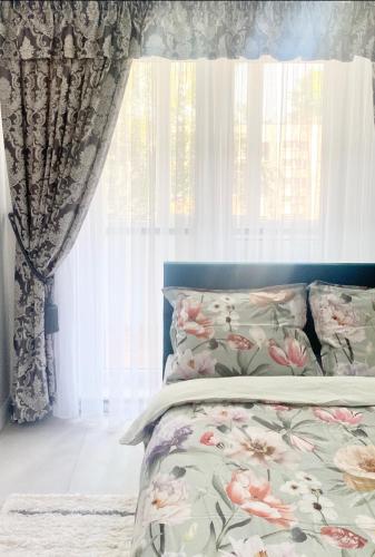 sypialnia z łóżkiem i oknem z zasłonami w obiekcie Jaukus butas Jonavoje w mieście Janów