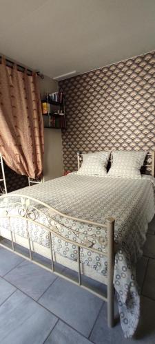 une chambre avec un grand lit avec des draps et des oreillers blancs dans l'établissement Bel appartement cosy indépendant, jolie terrasse, à Montpellier