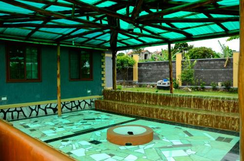 a covered patio with a toilet on the floor at Alice Gardens & Campsite in Entebbe