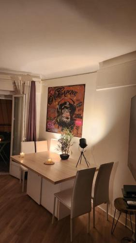 une table de salle à manger avec des chaises et un tableau au mur dans l'établissement Cannes Centre Palais Des Festivals Croisette, à Cannes