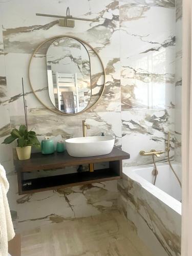 une salle de bain avec un lavabo et un miroir dans l'établissement Bel appartement Cap d Antibes avec terrasses et jardins, à Antibes