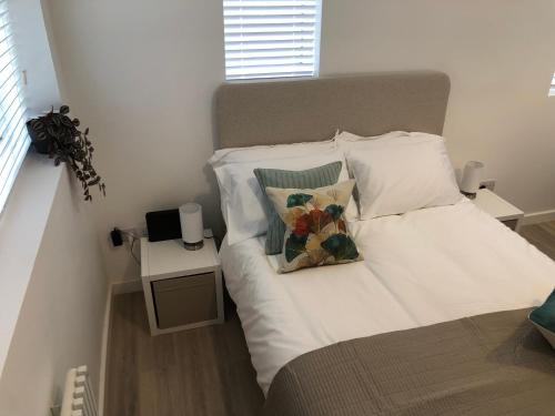 a bed with white sheets and pillows in a bedroom at On The Avenue Apt 3 in Nottingham