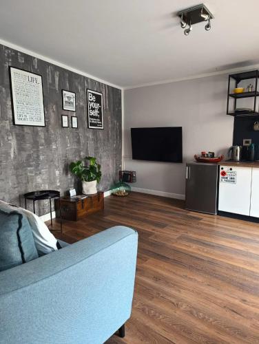 uma sala de estar com um sofá e uma televisão de ecrã plano em Loft 21 em Empoli