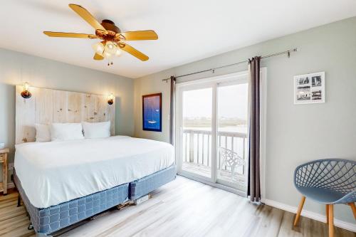 a bedroom with a bed and a ceiling fan at Blue Crab Bungalow in Padre Island