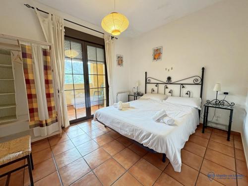 a bedroom with a large bed and a large window at Los Ciervos in Llanes