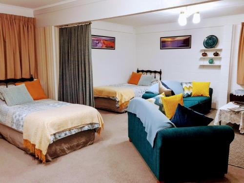 1 Schlafzimmer mit 2 Betten und einem Sofa in der Unterkunft Park View 'Home Away From Home' in Feilding