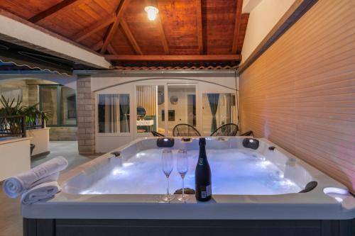 a bath tub with two wine glasses in it at Luxury Dream House Nea with jacuzzi in Makarska