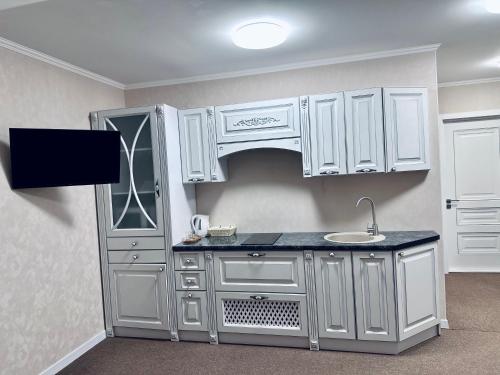 a kitchen with white cabinets and a sink at Hotel Korona in Kropyvnytskyi