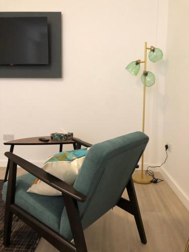a room with a chair and a table and a lamp at On The Avenue Apt 3 in Nottingham