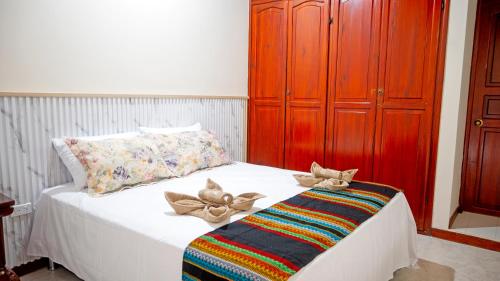 a bedroom with a white bed with a red cabinet at HOTEL PORTAL DE VITERBO Y RESTAURANTE LA FONDA in Viterbo
