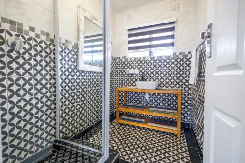 a bathroom with a shower with a sink and a mirror at Safi Luxury Apartment - 3 in East London