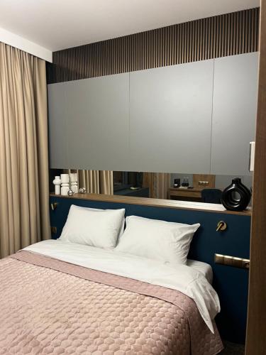 um quarto com uma cama grande e uma cabeceira azul em Four Sisters Luxury Rooms in Siauliai em Siauliai