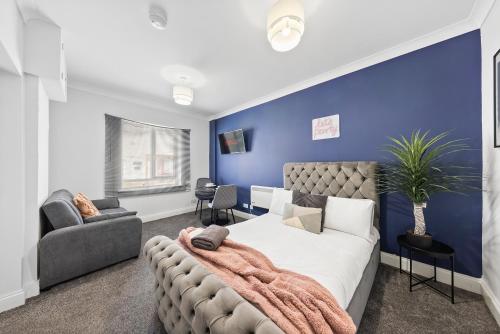 a bedroom with a large bed and a blue wall at Chic Flat in Medway Comfort & Style in Chatham