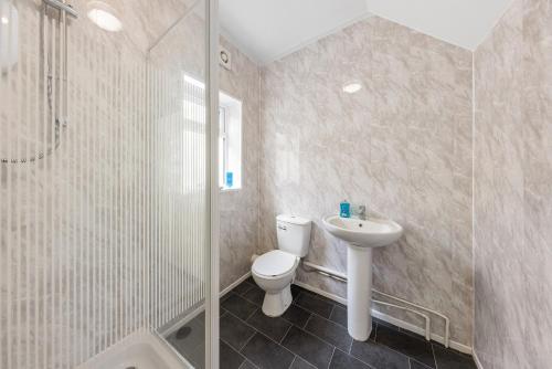 a bathroom with a toilet and a sink and a shower at Chic Flat in Medway Comfort & Style in Chatham