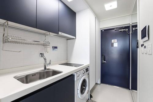 uma cozinha com um lavatório e uma máquina de lavar roupa em Park View Terrace em Paju