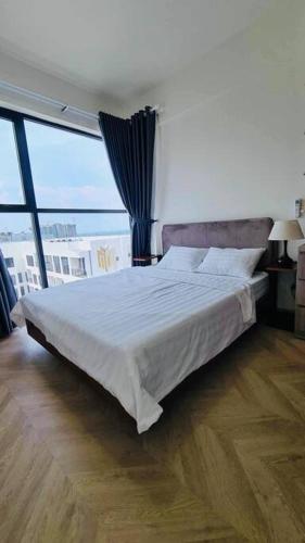 a bed in a room with a large window at Nicole House in Gò Công