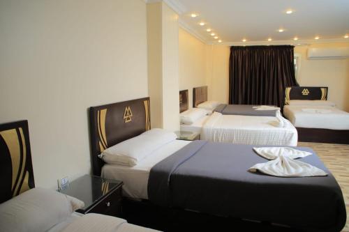une chambre d'hôtel avec 3 lits dans l'établissement MagiC Pyramids INN, au Caire