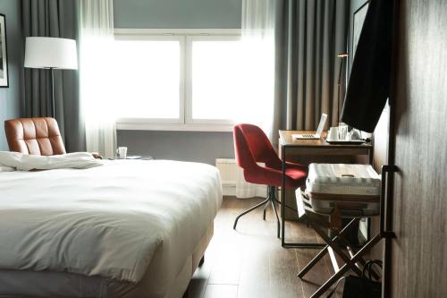 a bedroom with a bed and a desk and a window at Radisson Blu Airport Terminal Hotel in Arlanda