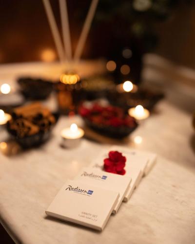 a table with a napkin with a rose on it at Radisson Blu Hotel, Amman Galleria Mall in Amman