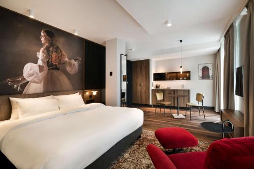 a hotel room with a bed and a large painting on the wall at Radisson RED Hotel & Radisson RED Apartments, Kraków in Kraków