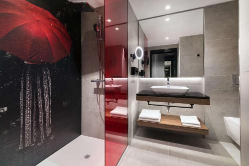 a bathroom with a sink and a red umbrella at Radisson RED Hotel & Radisson RED Apartments, Kraków in Kraków