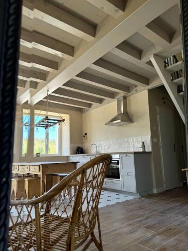une cuisine avec une table et une chaise dans une pièce dans l'établissement Chic & champêtre au cœur du Haut-Jura, à Lamoura