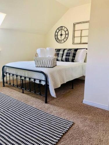 a bedroom with a bed with a clock on the wall at The Founders Suite at The Historic Kanab Inn in Kanab