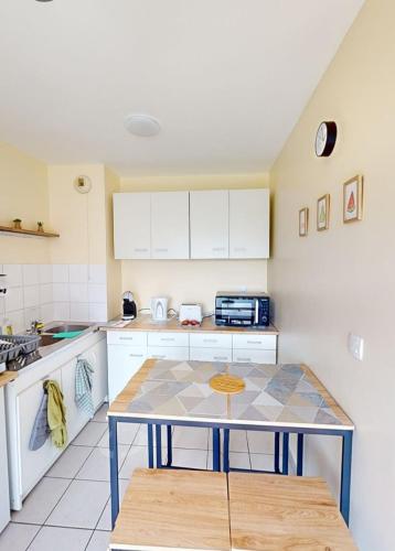 une cuisine avec des armoires blanches et une table dans l'établissement appartement avec balcon et ascenseur sur calais, à Calais
