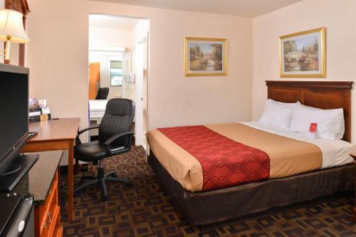 Bellmawr Economy Inn Bellmawr-Philadelphia Area في بيلماور: غرفة في الفندق مع سرير ومكتب