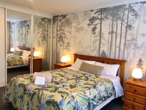 a bedroom with a bed with a forest wallpaper at Fashion,Bright and Spacious,Superior location in Hamilton