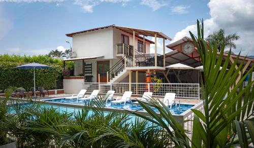 Villa con piscina frente a una casa en HOTEL PORTAL DE VITERBO Y RESTAURANTE LA FONDA, en Viterbo