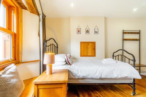 une chambre avec un lit et une table avec une lampe dans l'établissement Cottontail Cottage, à Staveley