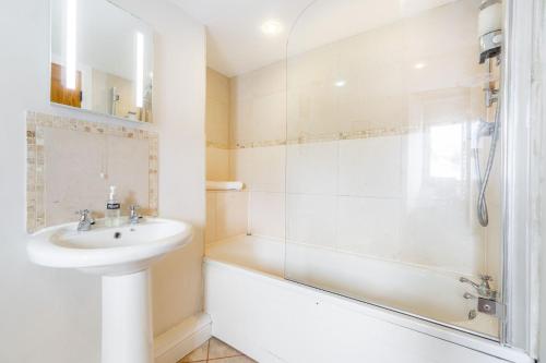une salle de bain blanche avec lavabo et douche dans l'établissement Cottontail Cottage, à Staveley