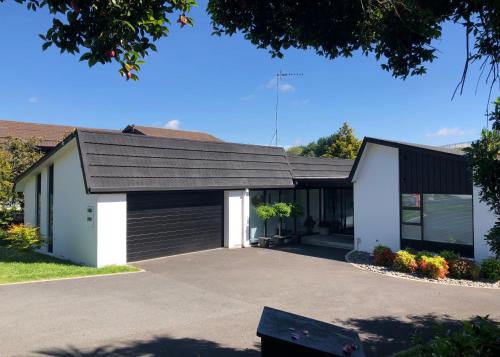 a house with a black roof and a garage at Fashion,Bright and Spacious,Superior location in Hamilton