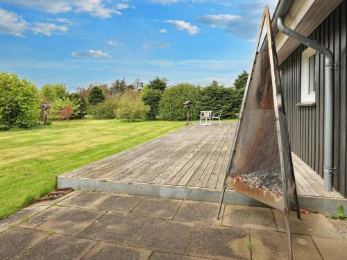 a wooden deck with a picnic table on the side of a house at 7 person holiday home in Fjerritslev-By Traum in Fjerritslev