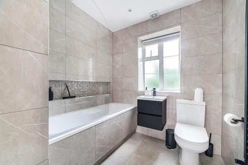 een badkamer met een bad, een toilet en een wastafel bij Arte Stays - New & Spacious 2 Bedroom Flat - close by Wembley Stadium - Parking in Londen