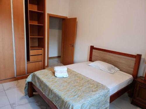 a bedroom with a bed with two towels on it at Apartamento Gamboa 1 in Praia