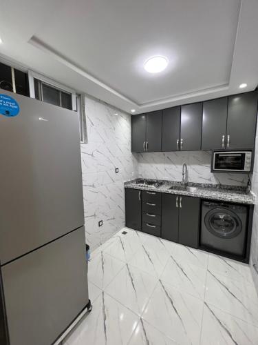 a kitchen with a refrigerator and a sink in it at Duplex familial 3 chambres au cœur de la Corniche de Tanger in Tangier