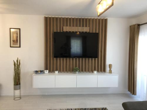 Comfort Residence Luxury Apartment في كرايوفا: غرفة معيشة مع خزانة بيضاء مع تلفزيون