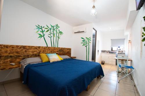 a bedroom with a bed with a blue blanket at Isla Venados Habitaciones Vacacionales in Mazatlán