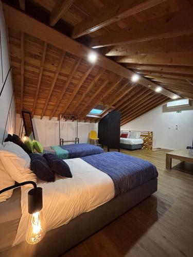 2 bedden in een grote kamer met houten plafonds bij B&C Furnas House in Furnas