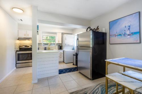 a kitchen with a stainless steel refrigerator and a table at Sparkling Oasis near Downtown ST Pete/Beach in St. Petersburg