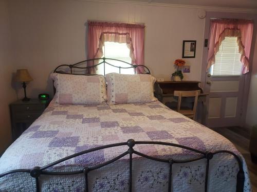 a bedroom with a bed with a purple quilt at Serenity Motel in Shaftsbury