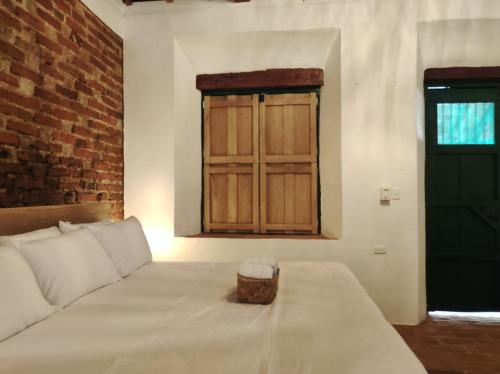 a bedroom with a bed and a green door at HOTEL NIETO MOMPOX, ubicado en el corazón del centro histórico, frente al rio magdalena en zona de malecón in Mompos