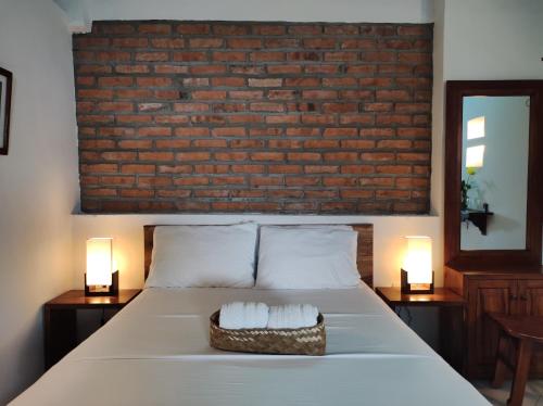 a bedroom with a bed with a brick wall at HOTEL NIETO MOMPOX, ubicado en el corazón del centro histórico, frente al rio magdalena en zona de malecón in Mompos