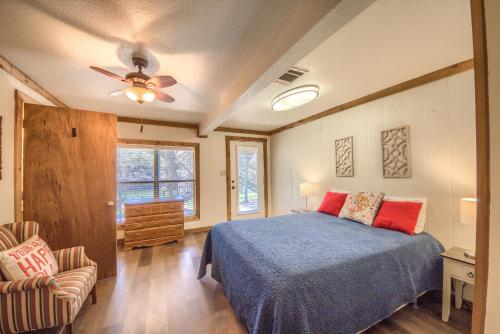 une chambre avec un lit et un ventilateur de plafond dans l'établissement Hondo's River Haus RR 1300, à Canyon Lake