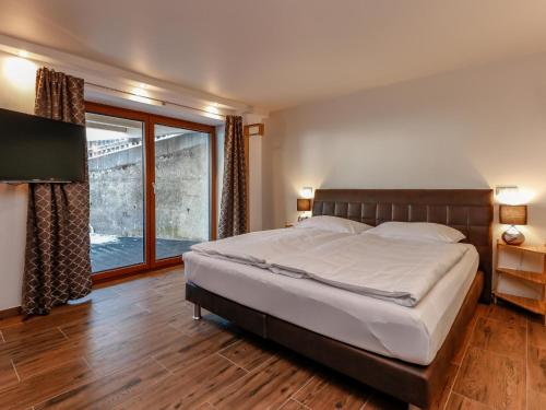 1 dormitorio con cama grande y ventana grande en Stacherl en Rauris